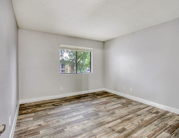 A room with wooden flooring and a window.