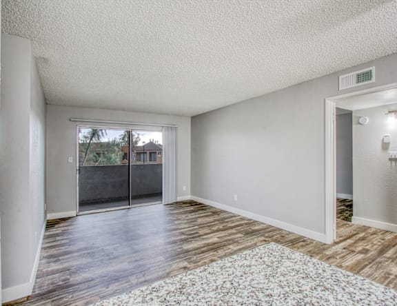 A room with a sliding glass door leading to a backyard.