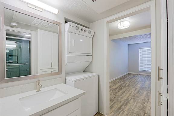 A white kitchen with a sink, stove, and oven.