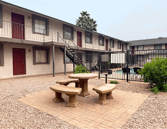 A courtyard with a table and chairs surrounded by buildings.