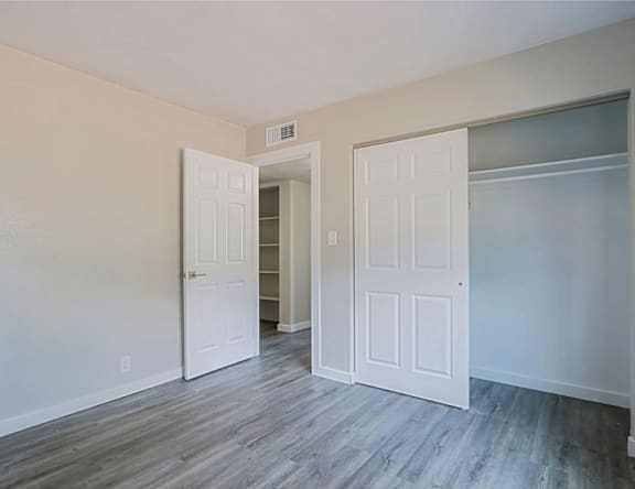 A room with two white doors and a grey floor.