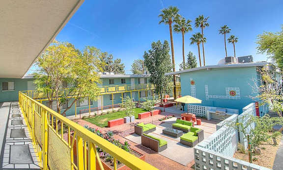 A sunny day at the outdoor seating area of a colorful building.