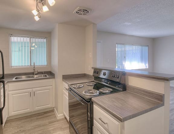 A kitchen with a stove top oven and a sink.