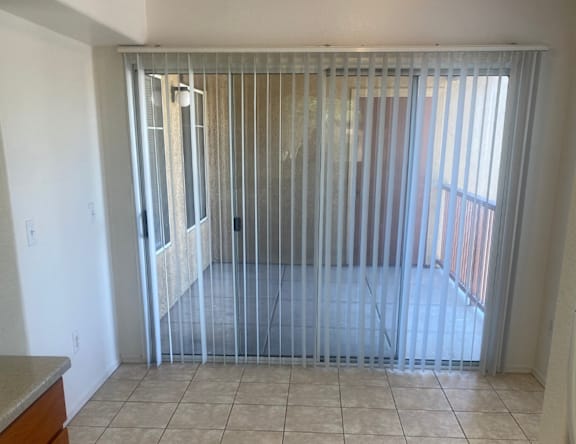 A room with a tiled floor and a sliding glass door.