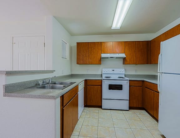 A kitchen with white appliances and wooden cabinets.