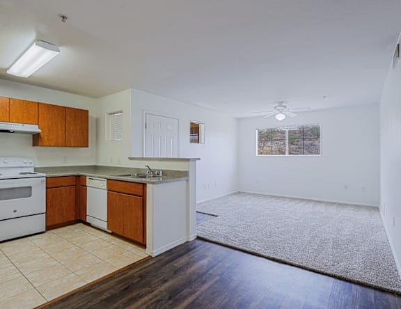A kitchen with white appliances and wooden cabinets.