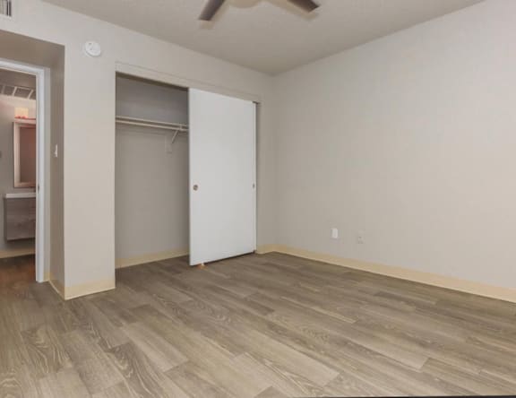 A room with a white door and a ceiling fan.