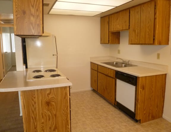 A kitchen with wooden cabinets and a white counter top.