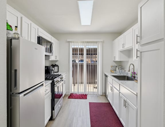 A kitchen with white appliances and cabinets.