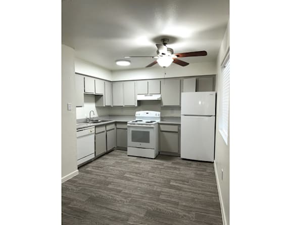 A kitchen with white appliances and cabinets.