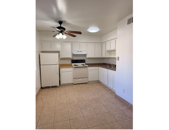 A kitchen with white appliances and cabinets.