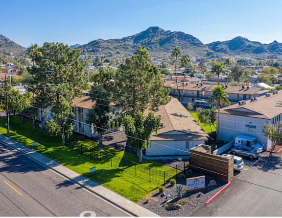 A sunny day in a residential area with houses and trees.