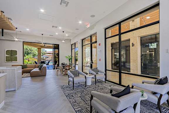A spacious living room with a variety of seating options and a view of the outdoors.