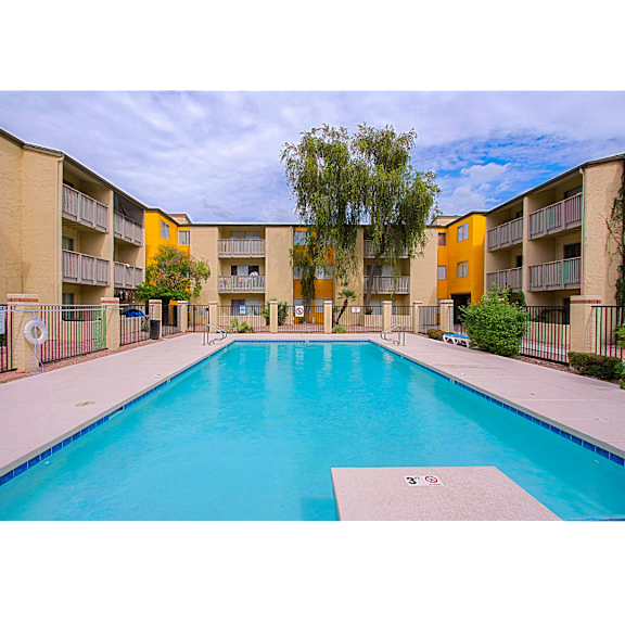 A swimming pool in front of apartment buildings.