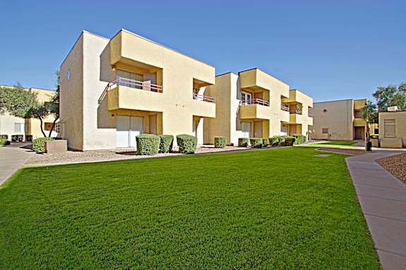 A modern building with a yellow facade and balconies.