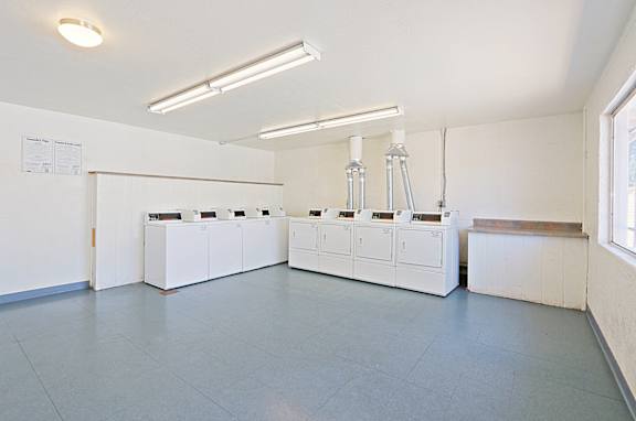 A clean, empty room with white cabinets and a window on the right side.