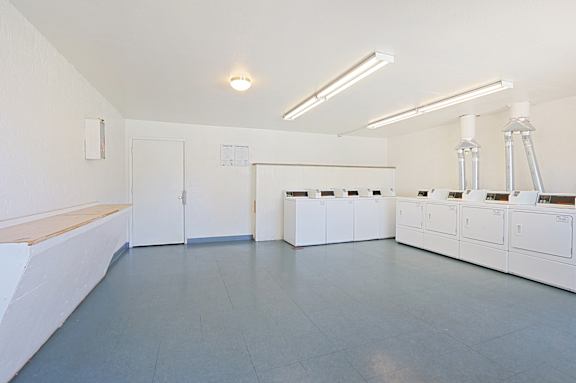 A room with white cabinets and a light brown bench.