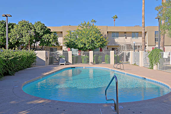 A small pool with a metal ladder in front of a building.