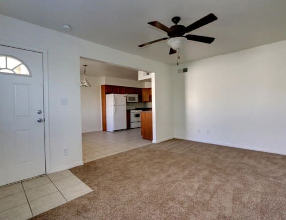 A room with a ceiling fan and carpeted floor.