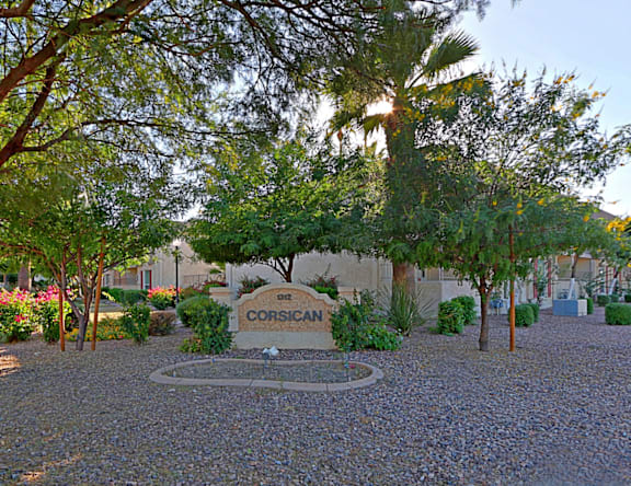A sign that says Corsican stands in the middle of a gravel area.