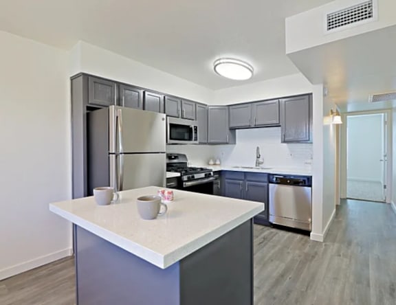 A kitchen with a white countertop and a refrigerator.