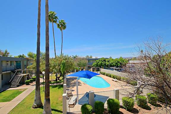 A pool surrounded by a fence and trees.