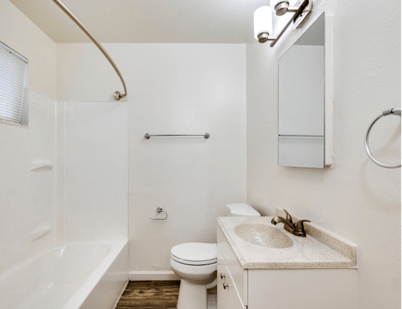 A white bathroom with a toilet, sink, and bathtub.