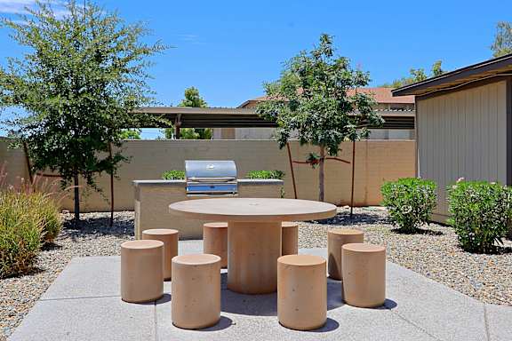 A concrete table surrounded by concrete stumps in a garden.