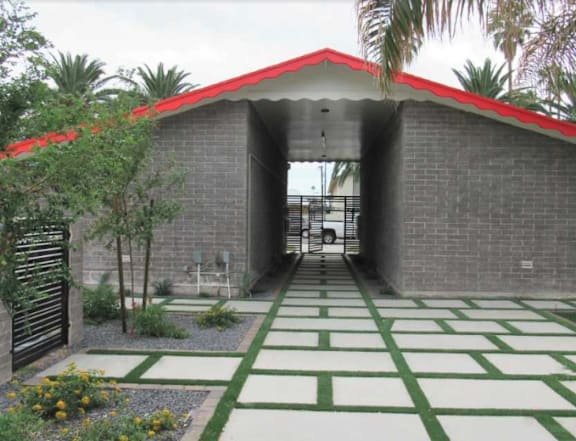 A house with a red roof and a garden in front.