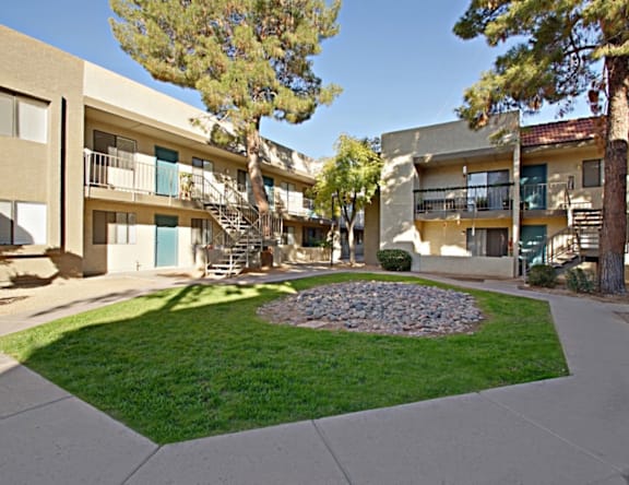 A courtyard with a circular bed of rocks in the center.