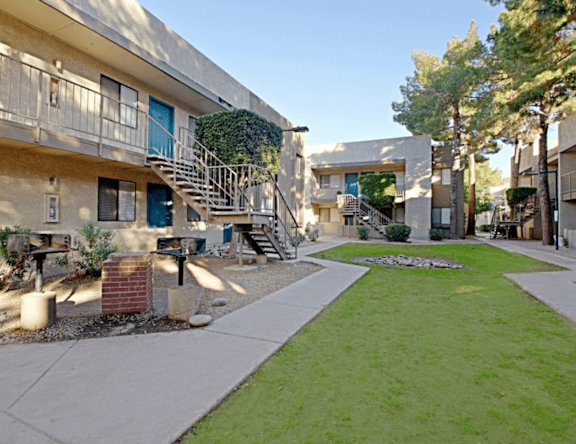 A sunny day at a residential area with apartment buildings and a green lawn.