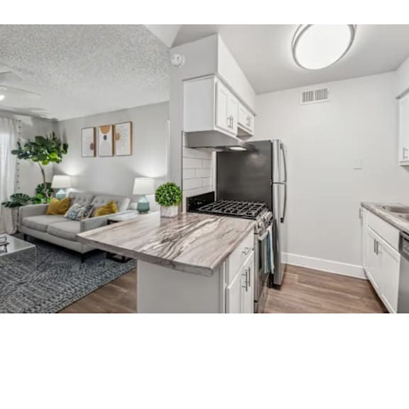 A kitchen with a refrigerator, stove, and oven.