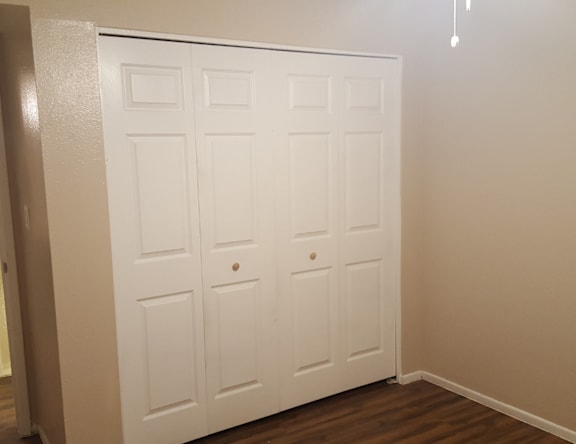 A white double door is closed and has a small knob on the right side of the right door.