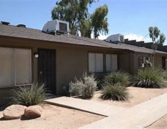 A house with a brown roof and a driveway in front.