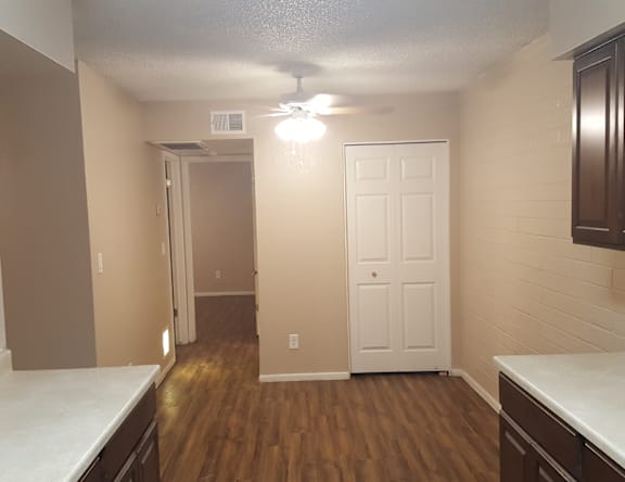 A room with a white door and a ceiling fan.