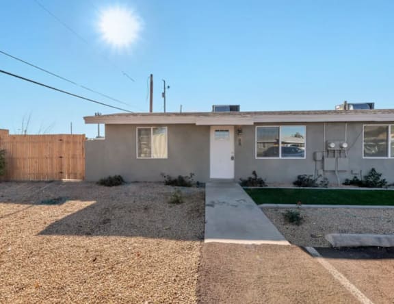 A house with a gravel driveway and a wooden fence.
