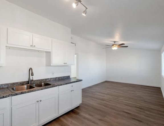 A kitchen with white cabinets and a granite countertop.