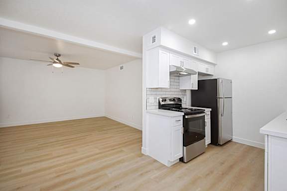 A kitchen with a refrigerator, stove, and oven.