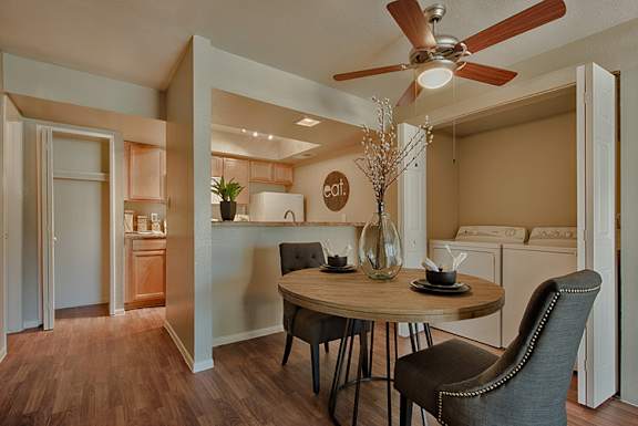 A dining room with a round table and chairs.
