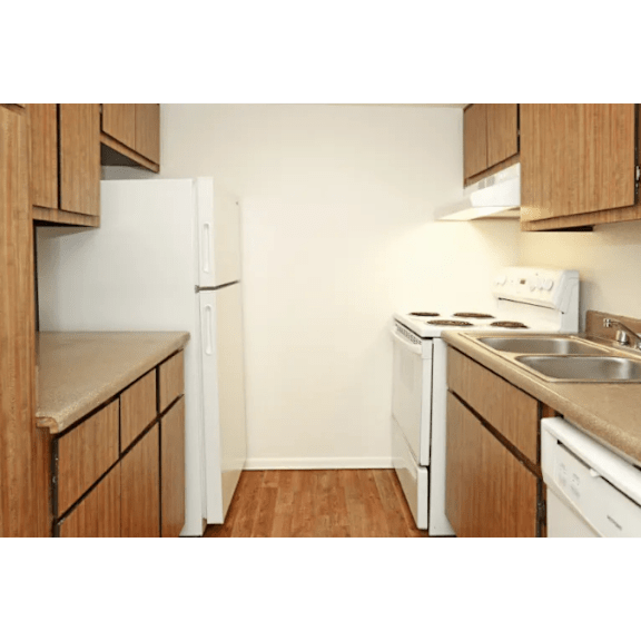A kitchen with a white refrigerator, white stove, and white oven.