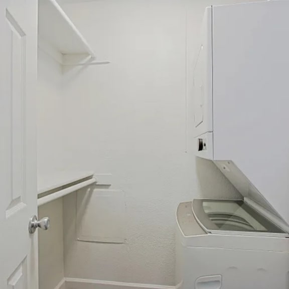A white laundry room with a washer and dryer.