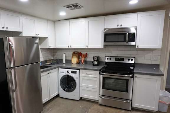 A kitchen with white cabinets and stainless steel appliances.