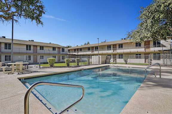 A swimming pool in front of apartment buildings.