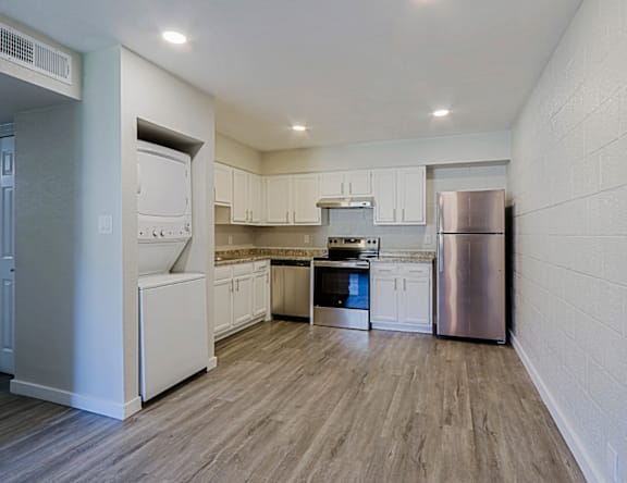 A kitchen with white cabinets and a stainless steel refrigerator.