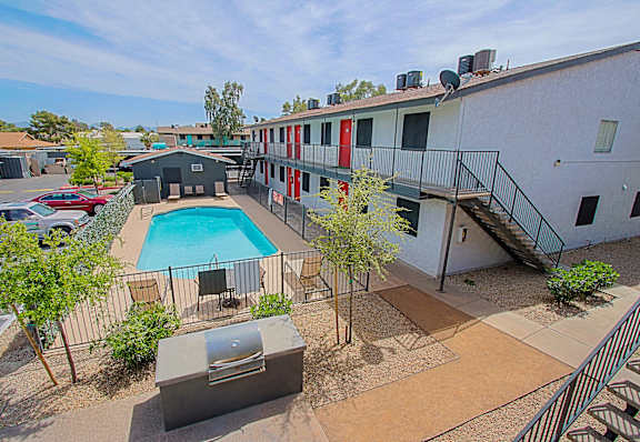 A pool surrounded by a fence and a building.