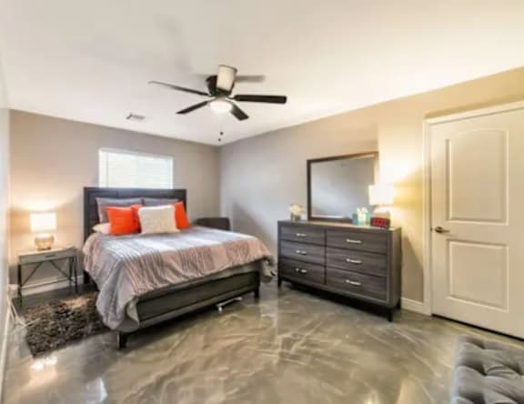 A bedroom with a bed, dresser, and mirror.