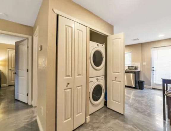 A laundry room with a washer and dryer built into the cabinetry.