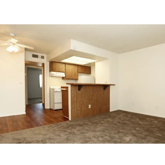 A kitchen area with a refrigerator, dishwasher, and a counter.