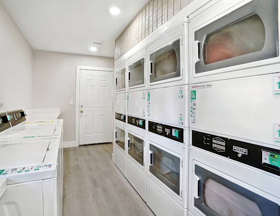 A row of white ovens are lined up in a room.