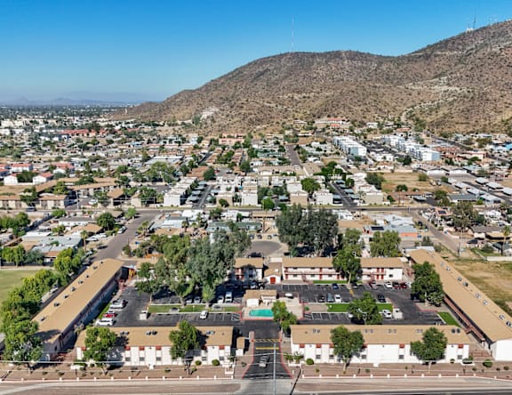 A small town with a large building in the center and a mountain in the background.